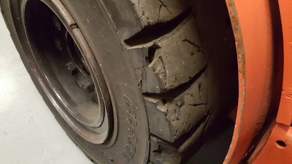 An example of a damaged but useable tire. A small amount of rubber is missing and there are some cracks in the rubber, but nothing that damages the integrity of the tire.